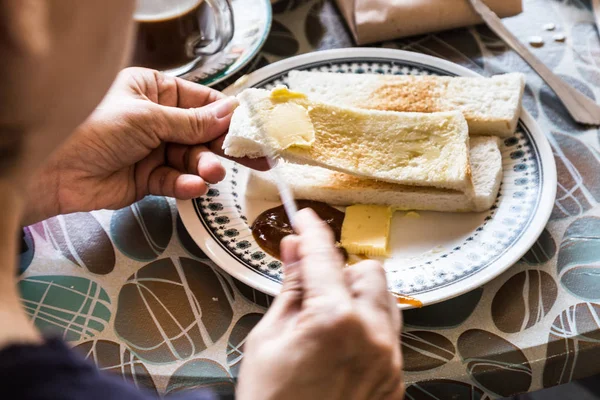 Rad person gäller ångad bröd smör och kaya — Stockfoto