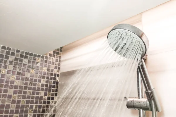 Shower head with refreshing water droplets spray in bathroom — Stock Photo, Image