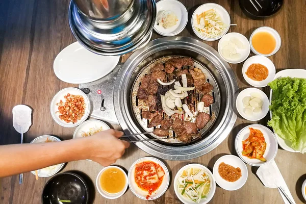 Person Grill Rindfleisch auf Grill Grube während koreanische Mahlzeit eingestellt — Stockfoto