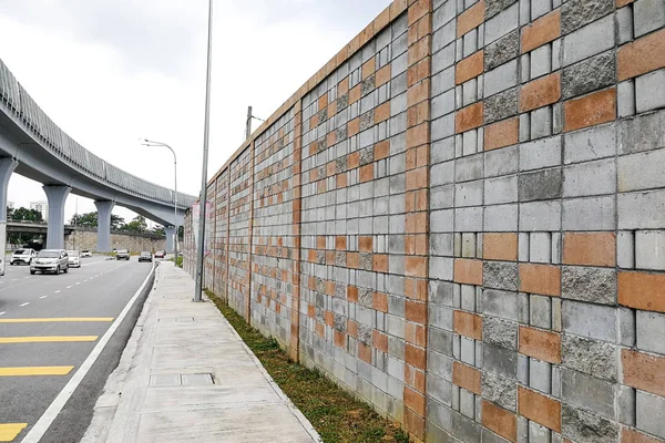 Concrete sound barrier wall next to busy highway rail track