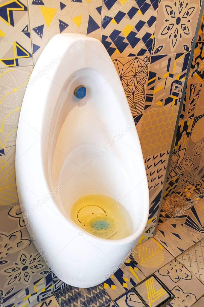 Clogged smelly men urinal sanitary ware in public restroom toile