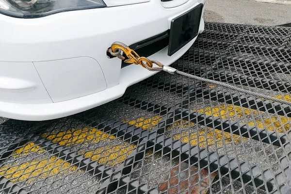 Автомобиль отбуксирован на платформу буксира с крюком и цепью — стоковое фото