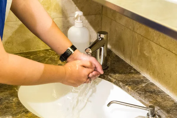 Людина миє руки антибактеріальною рідиною і водою — стокове фото