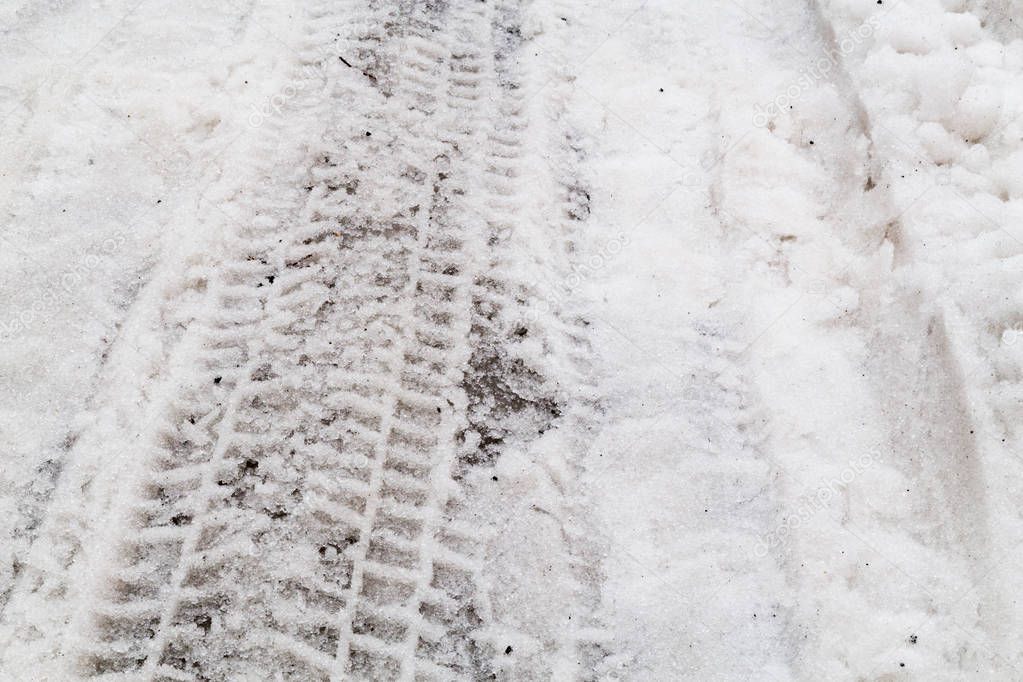 Close-up on tire track imprint on road with snow