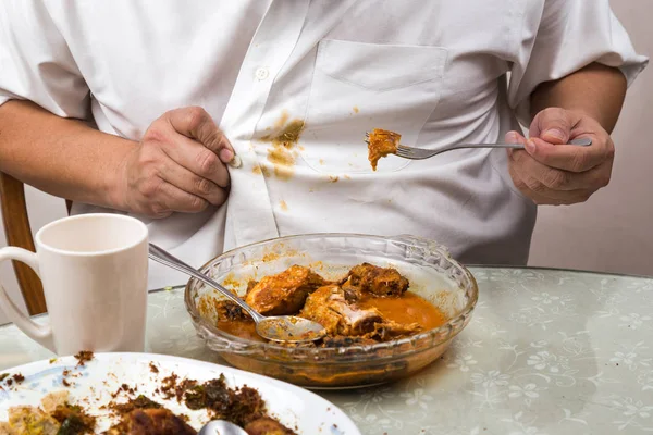 Person accidently spilled curry stain onto white shirt.