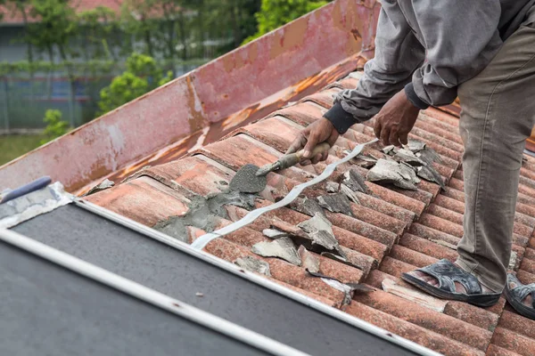 Aziatische werknemer veilige dakpannen met cement op oude gebouw — Stockfoto