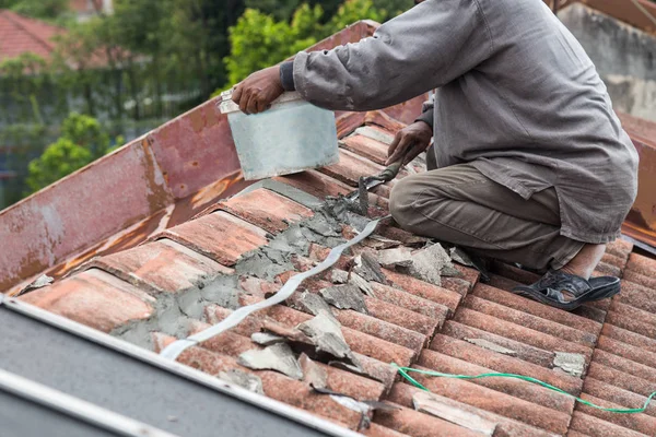 Trabajador asiático asegurar tejas con cemento en el edificio viejo — Foto de Stock