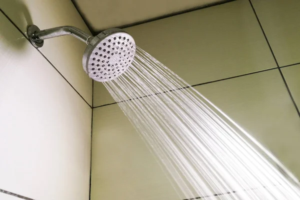 Cabezal de ducha con gotas de agua refrescante rociando en el baño —  Fotos de Stock