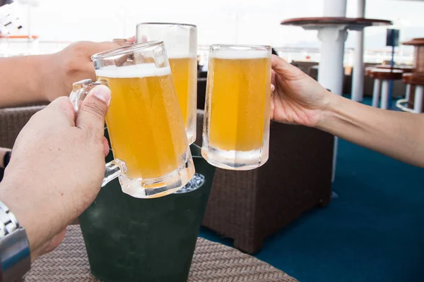 Drei Personen stoßen auf Feier mit Biergläsern an — Stockfoto