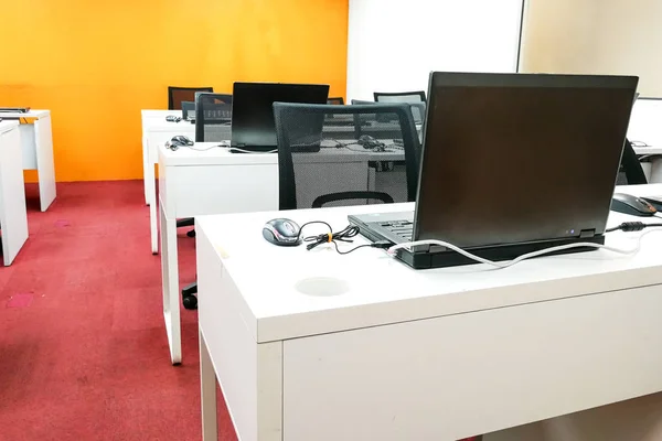 Aula de computadora vacía con monitores encima de la mesa — Foto de Stock