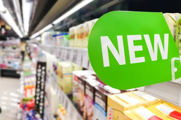 Nova sinalização de palavra na prateleira do supermercado para chegada de novos produtos — Fotografia de Stock