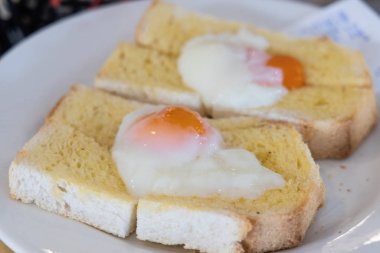 Kızarmış ekmeğin üzerinde yarı pişmiş yumurta, popüler Çin kahvaltısı.