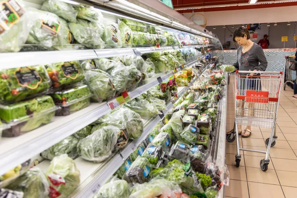 Asiatin kauft frisches Gemüse im modernen Supermarkt ein — Stockfoto