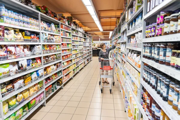 Serie asiatischer Frauen, die Lebensmittel in modernen Supermärkten einkaufen. — Stockfoto