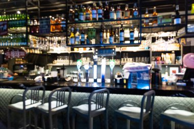 Barda içki ve taburelerle bulanık bir tezgah.