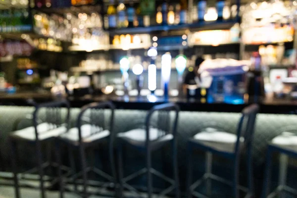 Blurred bar counter in pub with drinks and stools — 스톡 사진