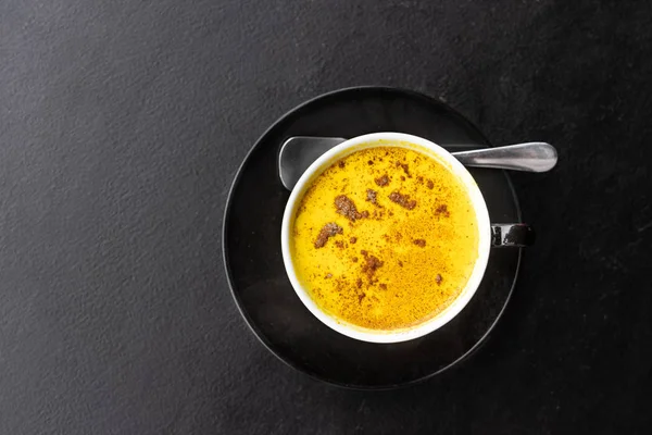 Servire di curcuma aromatica caffè nero contro tavolo scuro — Foto Stock