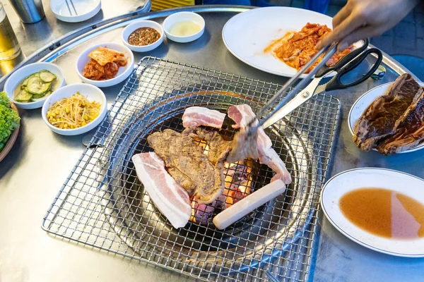 Вид сверху на корейское барбекю на гриле, с другими блюдами — стоковое фото