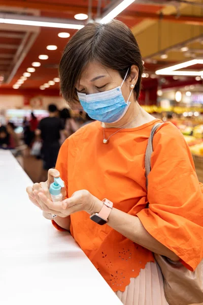 Femme asiatique appliquant un désinfectant sur la main pour la protection contre le virus de la grippe — Photo