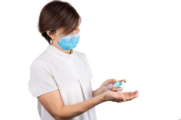 Femme asiatique avec masque facial appliquant un désinfectant sur la main pour la protection — Photo