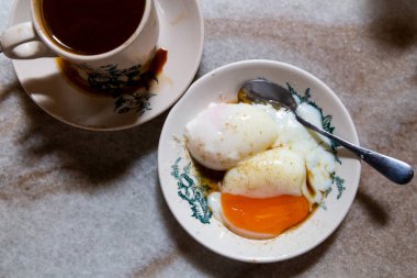 Yarı haşlanmış organik yumurta ve kahve, Malezya kopitiam 'da popüler besleyici Çin usulü kahvaltı. Düşük tuşlu ışıklandırma.