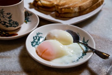 Yarısı haşlanmış organik yumurta, kahveli tost ekmeği, Malezya kopitiam 'da popüler Çin usulü kahvaltı. Düşük tuşlu ışıklandırma.