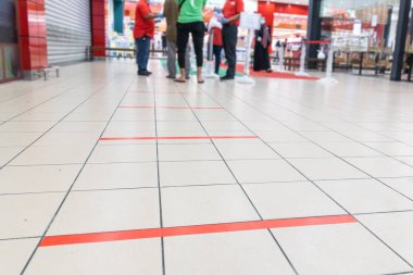 Malezya 'da süpermarketin girişinde, kuyruktaki insanlar arasında 1 metre boşluk ile sosyal mesafeler deneniyor.