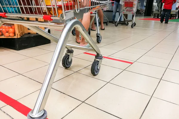 Social distancing being practiced at supermarket payment counter in Malaysia, with 1 meter gap between people in queue.