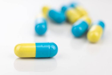 Beyaz arka planda grup tıbbı ilacının kapsül biçiminde yakın plan görüntüsü