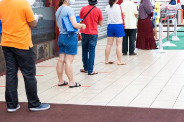 İnsanların Malezya 'da süpermarkete doğru kuyrukta en az 1 metre farkla ayrıldığı sosyal mesafeli yeni normal yaşam tarzı