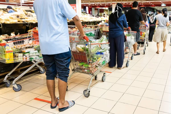 People embracing the new normal with social distancing in checking out at supermarket in Malaysia