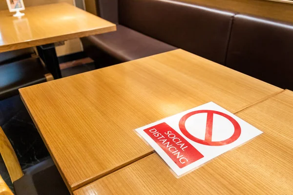 테이블 표지가 새로운 정상은 코로나 바이러스의 확산을 억제하기 사회적 거리를 — 스톡 사진