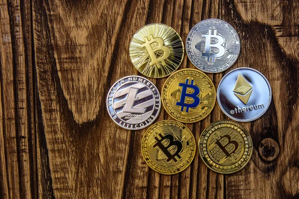  eski ahşap masa üzerinde bitcoin, litecoin ve ethereum yalan