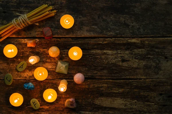 Objects for divination, runes and candle on a wooden background — Stock Photo, Image