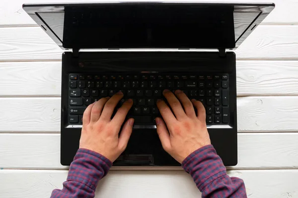 Man working at his laptop on white wooden background — Stock Photo, Image