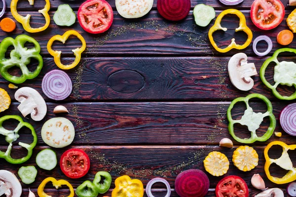 Sliced fresh vegetables on a wooden background and space for text in the center mockup — Stock Photo, Image