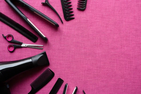 Herramientas de peluquería sobre un fondo rosa y espacio para el texto — Foto de Stock