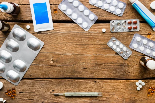 Diferentes pílulas médicas, antibióticos, gotas nasais, um termômetro — Fotografia de Stock