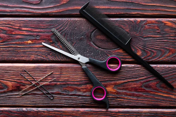 scissors and comb hairdresser tools on a wooden background