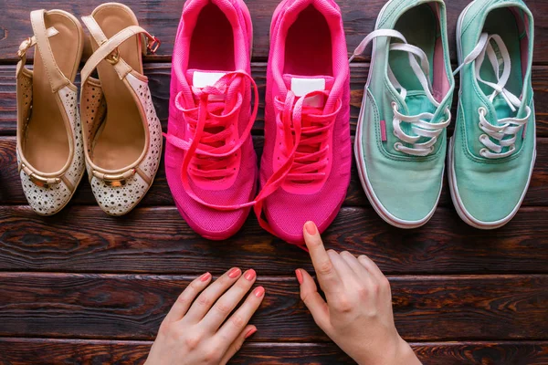 Dziewczyna wybiera buty na podłoże drewniane — Zdjęcie stockowe