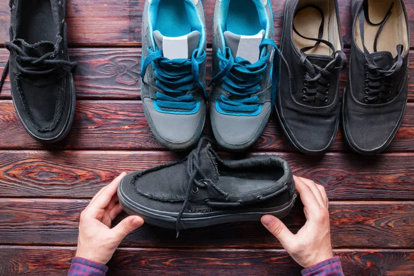 Człowiek wybiera gospodarstwa czarne mokasyny buty — Zdjęcie stockowe