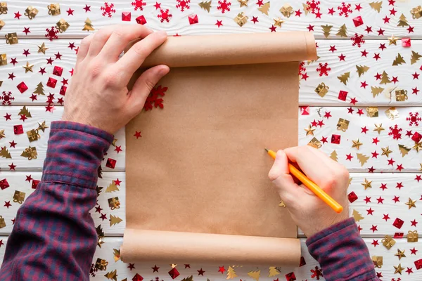 Homem escreve em uma lista de desejos de Natal — Fotografia de Stock