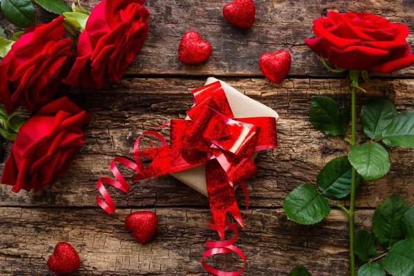 Gift and a bouquet of flowers on Valentine's Day — Stock Photo, Image