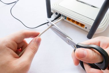adam Internet kablosu yönlendiriciye bağlı keser