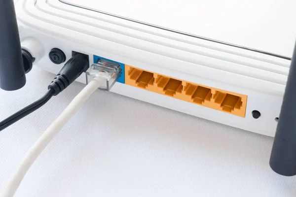 Roteador e o cabo de internet conectado de perto no fundo branco — Fotografia de Stock