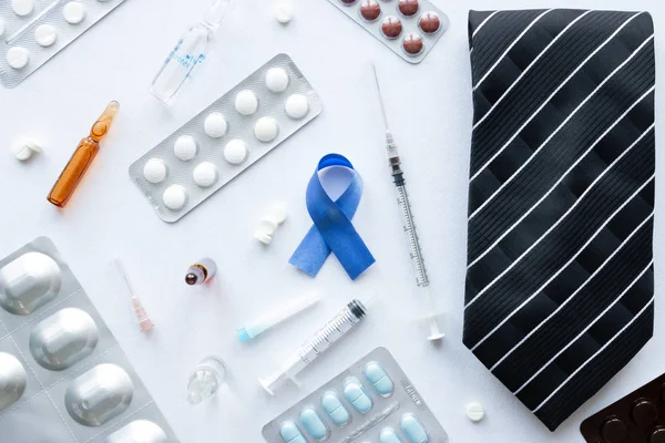 Símbolo de câncer de próstata, um laço e pílulas em um fundo branco — Fotografia de Stock