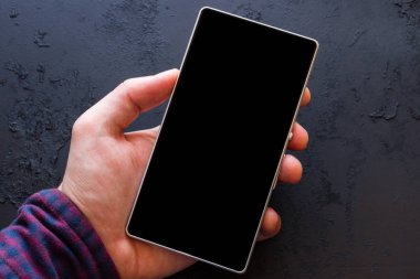 bir akıllı telefon yakın çekim bir siyah arka plan üzerinde tutan adam