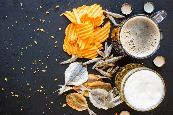 Cerveja e lanche em um fundo preto com espaço para texto — Fotografia de Stock