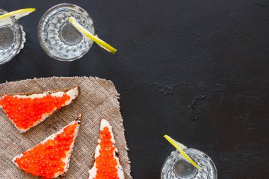 Kırmızı havyar ve votka metin için yer siyah bir zemin üzerine bir bardak sandviç