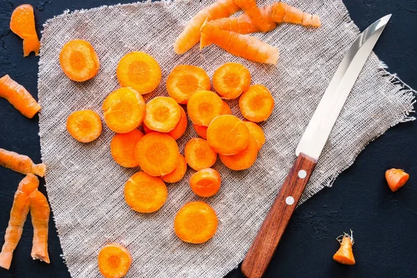 Peeled and chopped carrots and a knife on a napkin — Stock Photo, Image